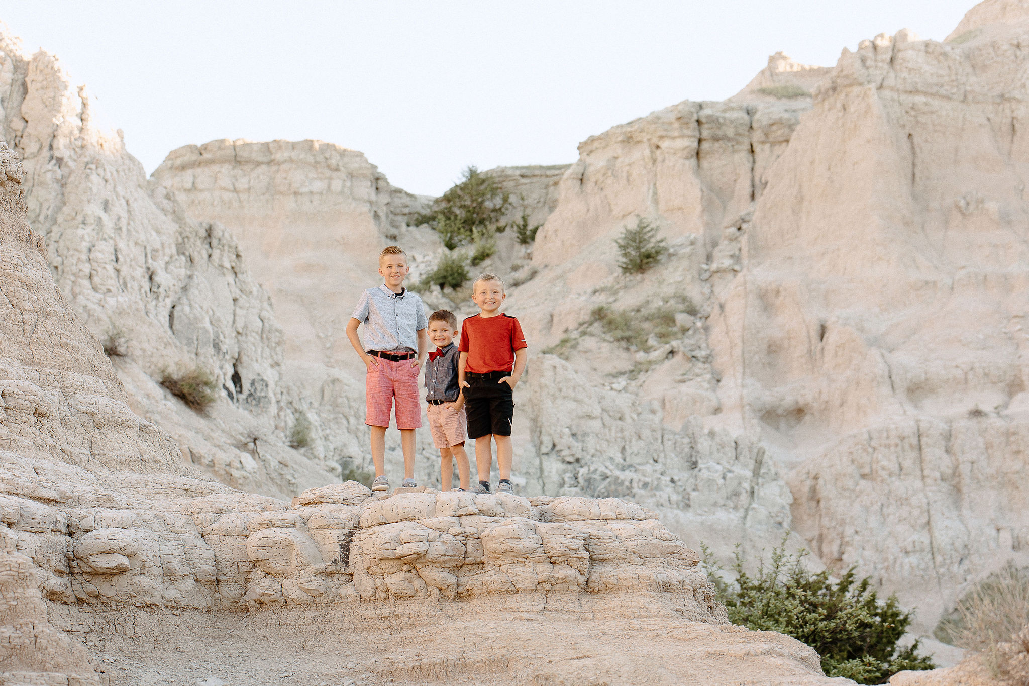 Three boys standing on a formation in Badlands National Park