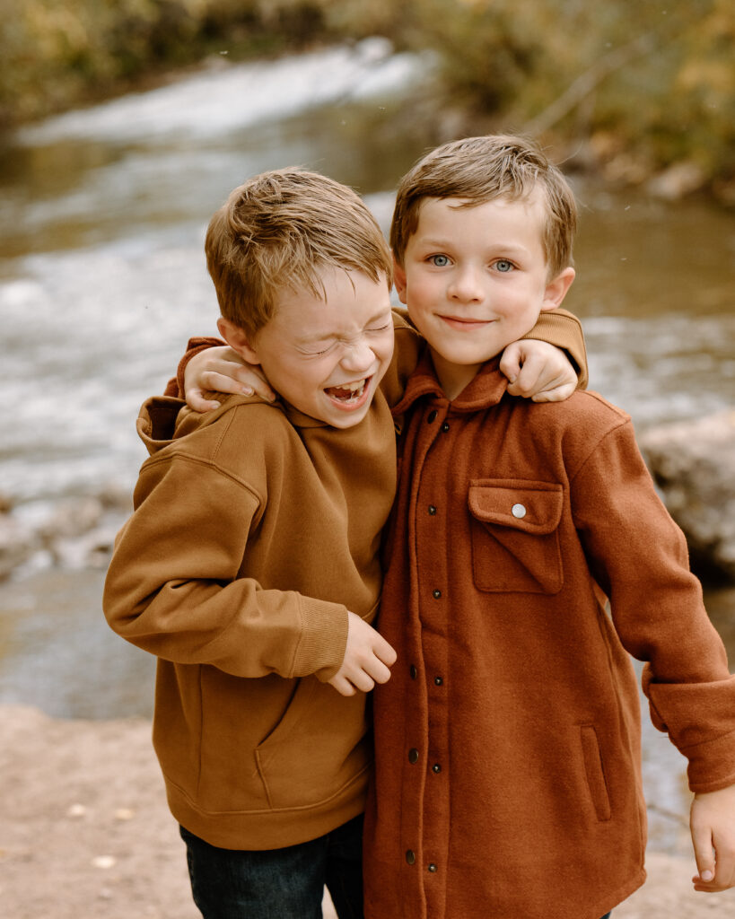 Two boys in fall colors with Rapid Creek behind them