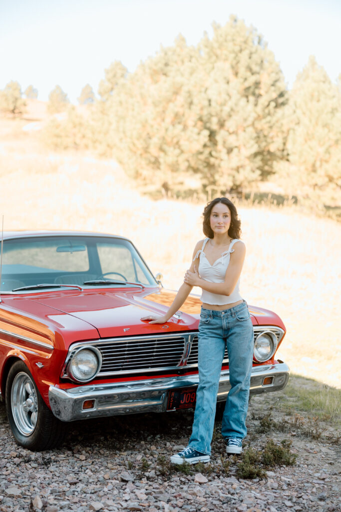 Senior photo of girl standing next to vintage car